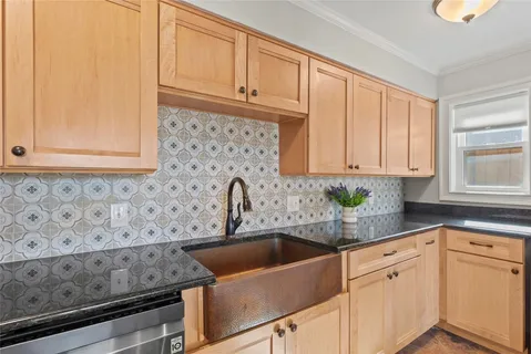a kitchen with stainless steel appliances granite countertop white cabinets a sink and dishwasher