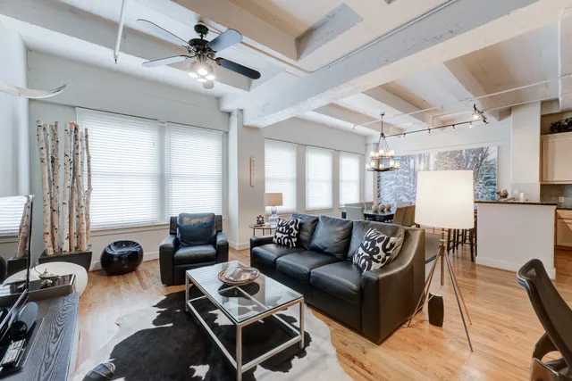 a living room with furniture a large window and a chandelier