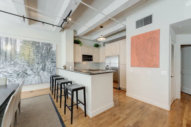 a kitchen with granite countertop a refrigerator and a stove top oven