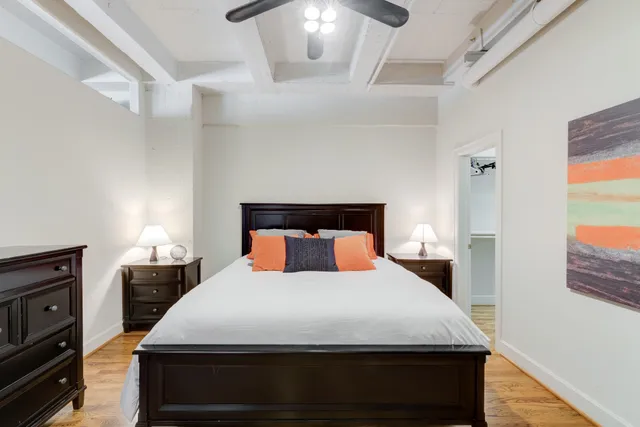 a bedroom with a bed and wooden floor