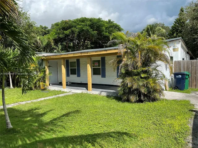a view of a house with a yard and tree s