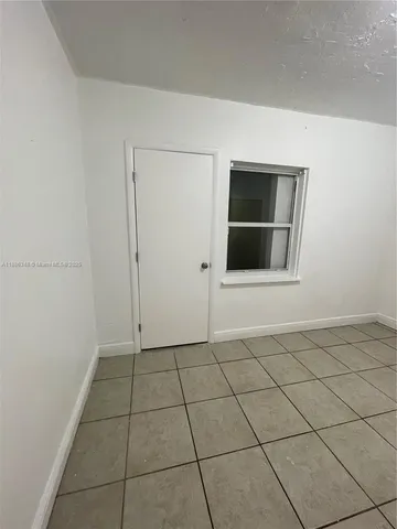 a view of a livingroom with an empty space and a window