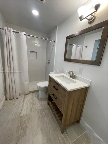 a bathroom with a double vanity sink mirror and toilet