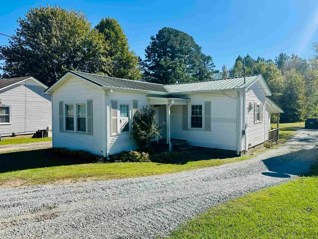 a front view of a house with yard and green space