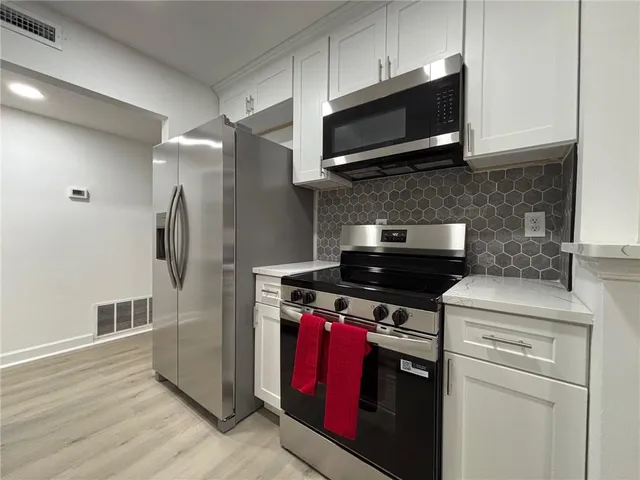 a kitchen with stainless steel appliances granite countertop a stove microwave and refrigerator