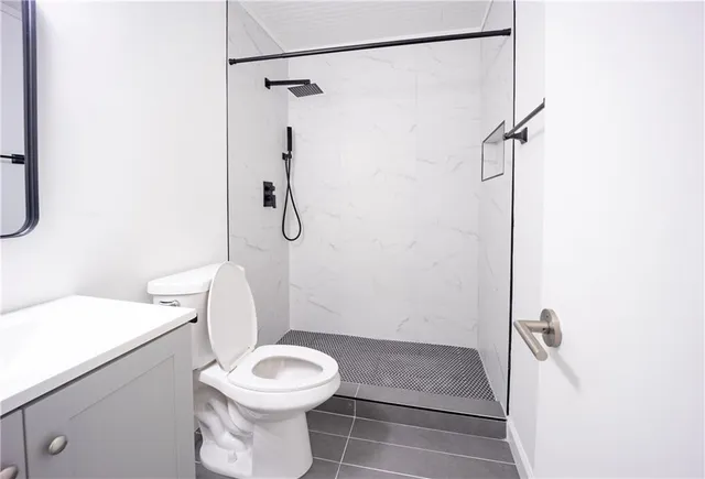 a bathroom with a toilet and a shower