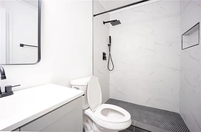 a white toilet sitting next to a bathroom sink and a shower