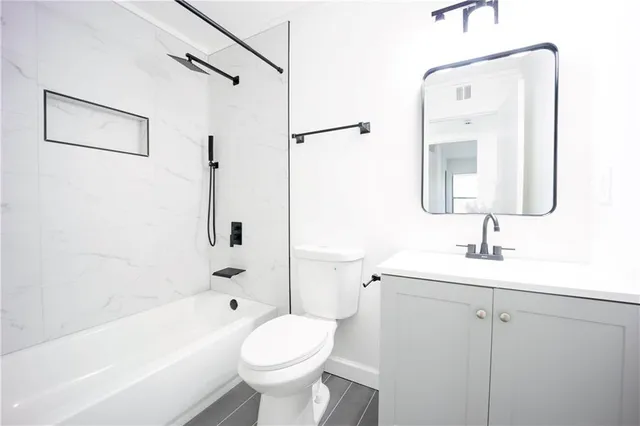 a bathroom with a toilet a sink a mirror and bathtub