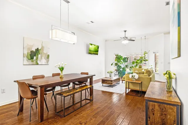 a view of a dining room with furniture a chandelier and wooden floor