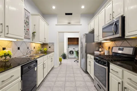 a kitchen with stainless steel appliances a sink stove top oven and cabinets