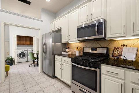 a kitchen with stainless steel appliances a stove a microwave a sink a refrigerator and cabinets