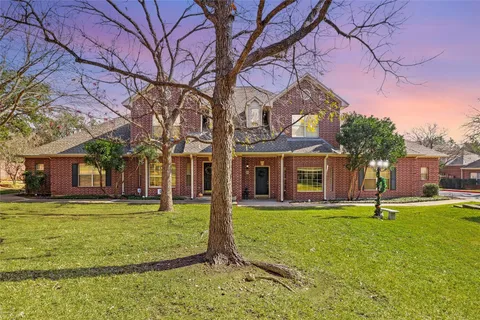 a view of a house with a big yard and large tree