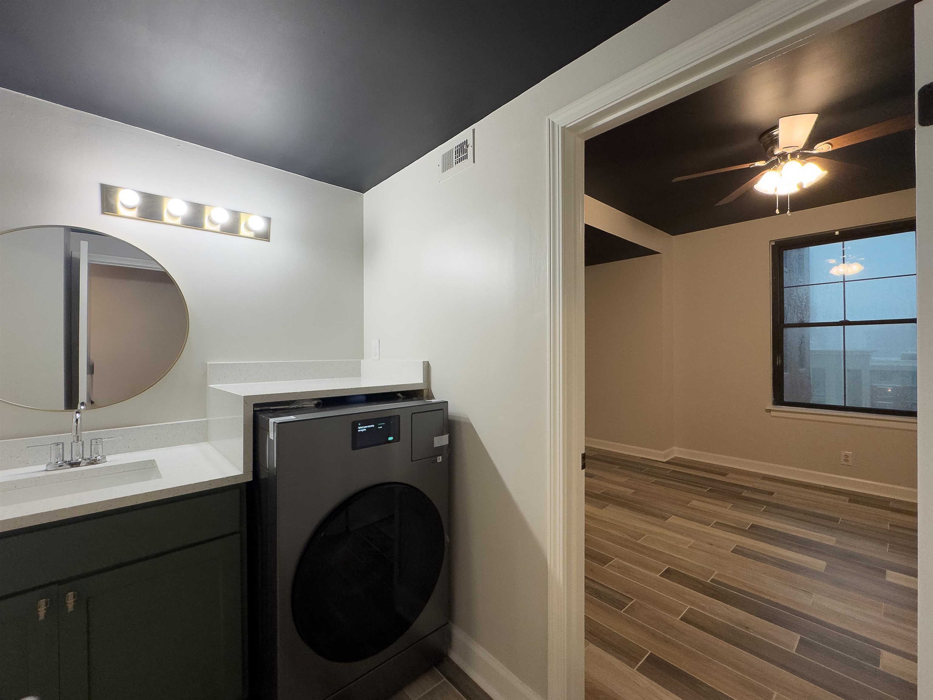 109 North Main Street, Unit 907 Memphis, TN 38103 - Photo 13 of 29 Bathroom vanity featuring a vessel sink, integrated countertop, and mounted circular mirror