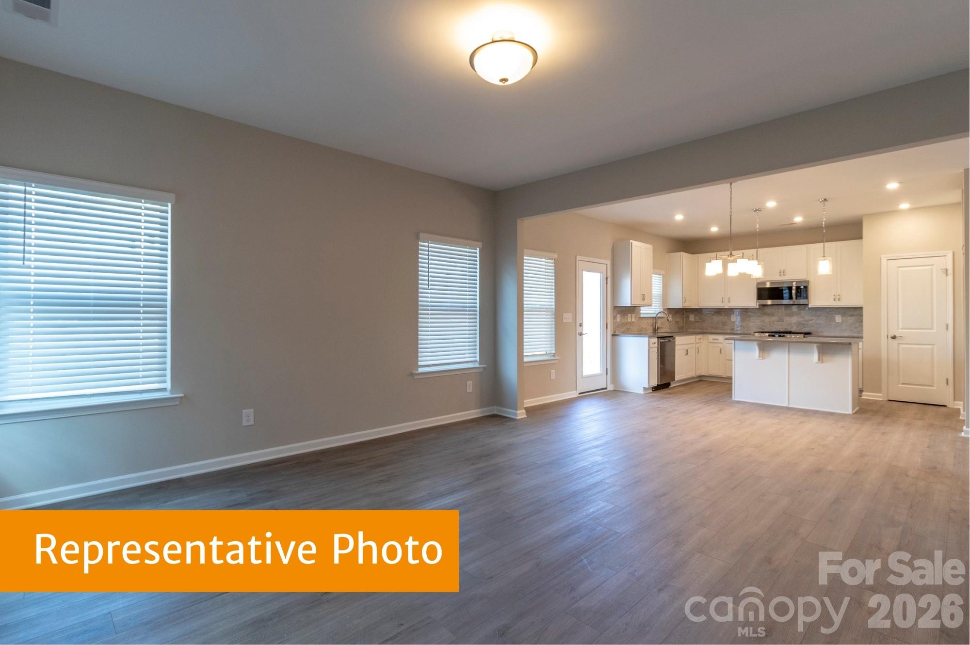 1918 Gibb Crossing Monroe, NC 28110 - Photo 15 of 19 a view of open kitchen with kitchen island wooden floors and stainless steel appliances