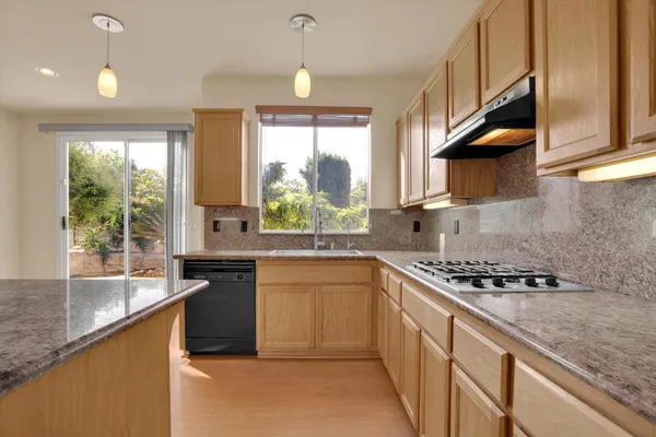 a kitchen with stainless steel appliances granite countertop a sink stove cabinets and wooden floor