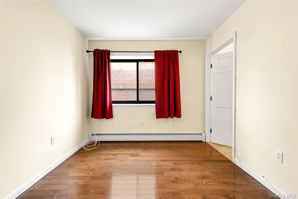 an empty room with wooden floor and a window