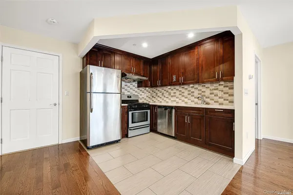 a kitchen with stainless steel appliances granite countertop a refrigerator and a stove
