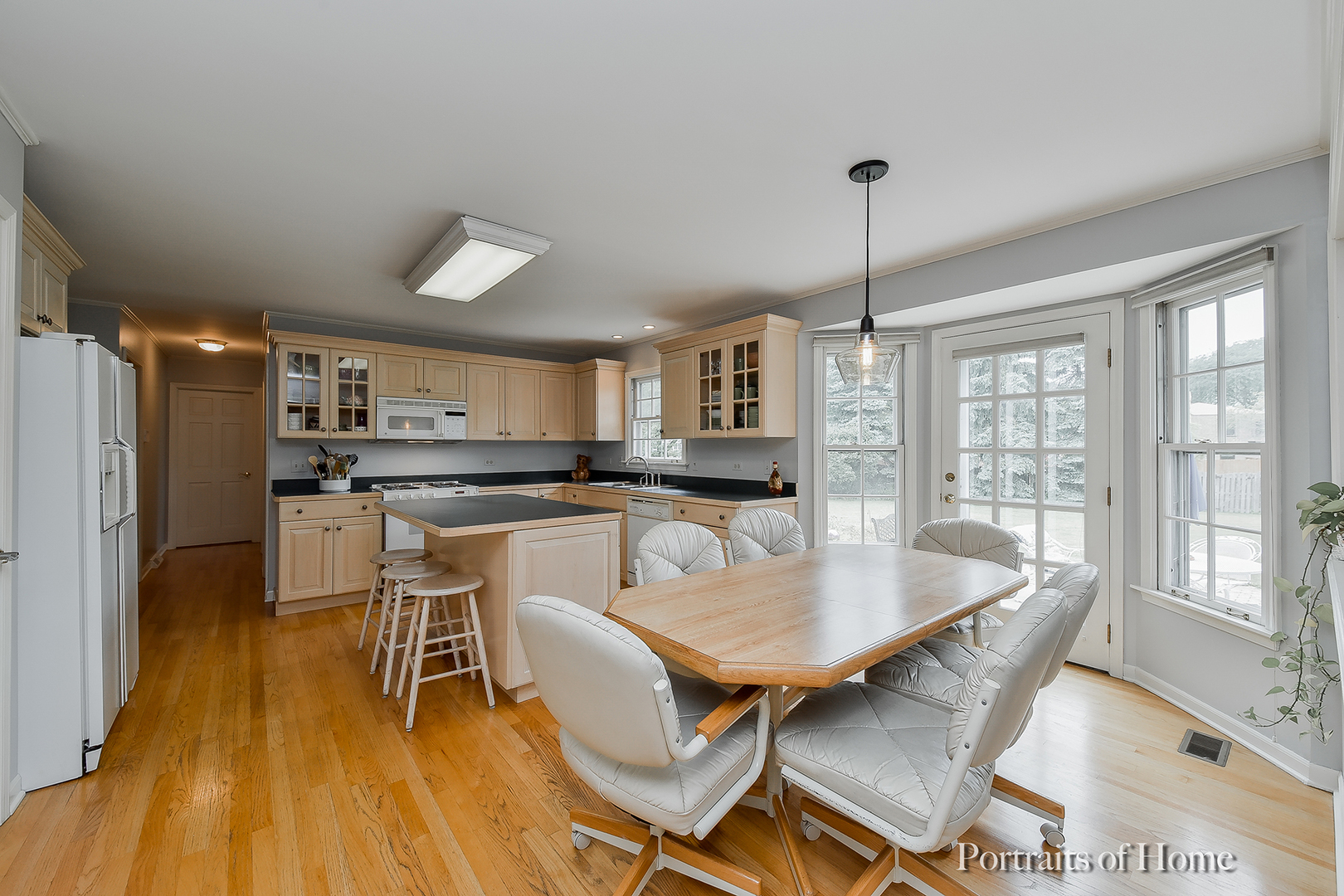 29 Christina Circle Wheaton, IL 60189 - Photo 7 of 28 a kitchen with a dining table chairs and refrigerator