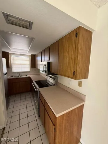 a kitchen with a sink a stove and cabinets