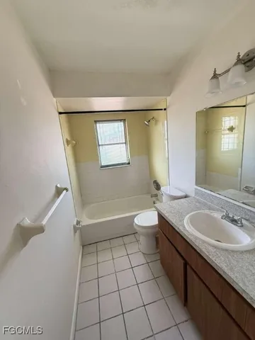 a spacious bathroom with a granite countertop sink a toilet and mirror
