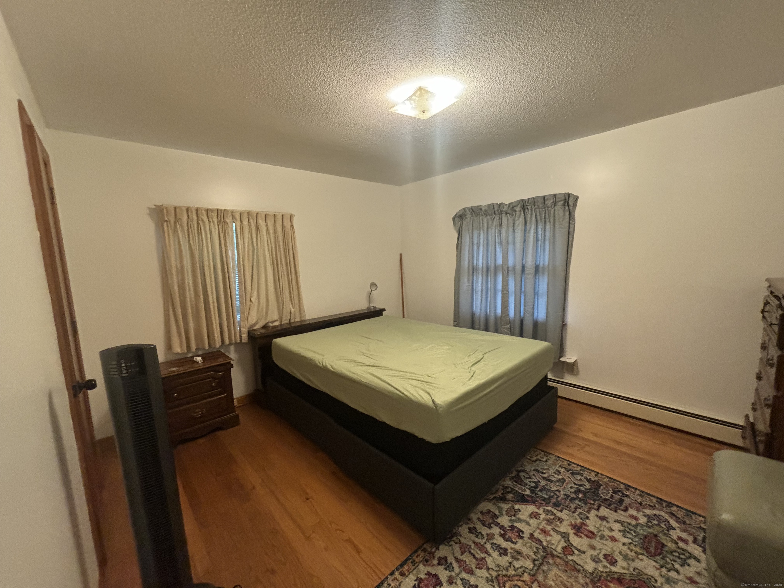 388 Chaffeeville Road Mansfield, CT 06268 - Photo 13 of 13 a bedroom with a bed and wooden floor