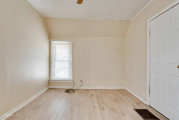 an empty room with wooden floor and window