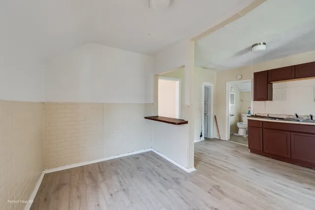 a view of a kitchen with wooden floor and electronic appliances