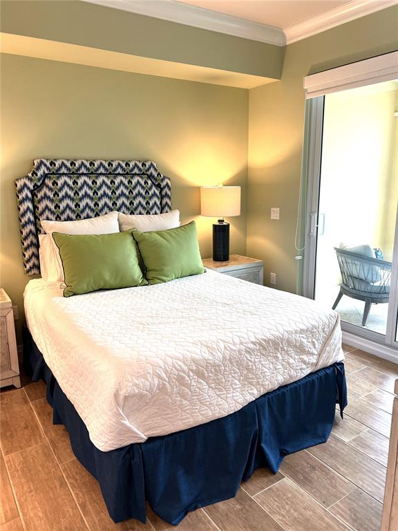 800 Collany Road, Unit 303 St. Petersburg, FL 33715 - Photo 29 of 48 a bedroom with a bed and wooden floor