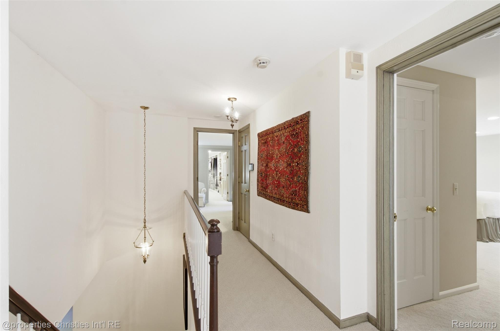 25235 Canterbury Road Franklin, MI 48025 - Photo 25 of 56 Upper-level hallway featuring carpet flooring, crisp white walls, and a traditional wood handrail with white balusters