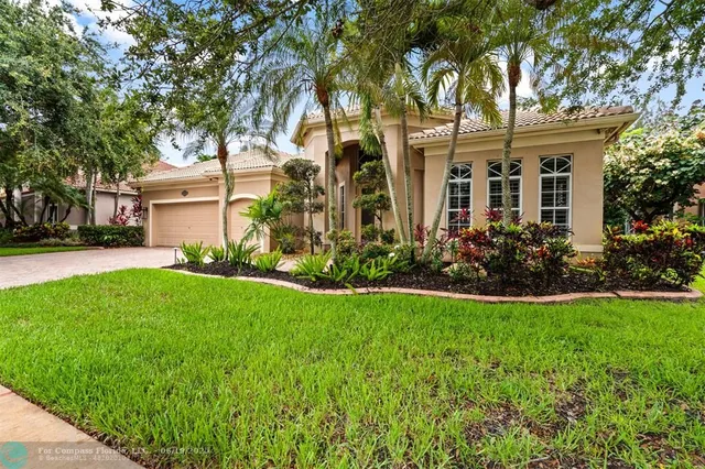 front view of house with a yard and potted plants