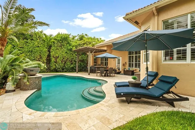 a patio with a table and chairs under an umbrella