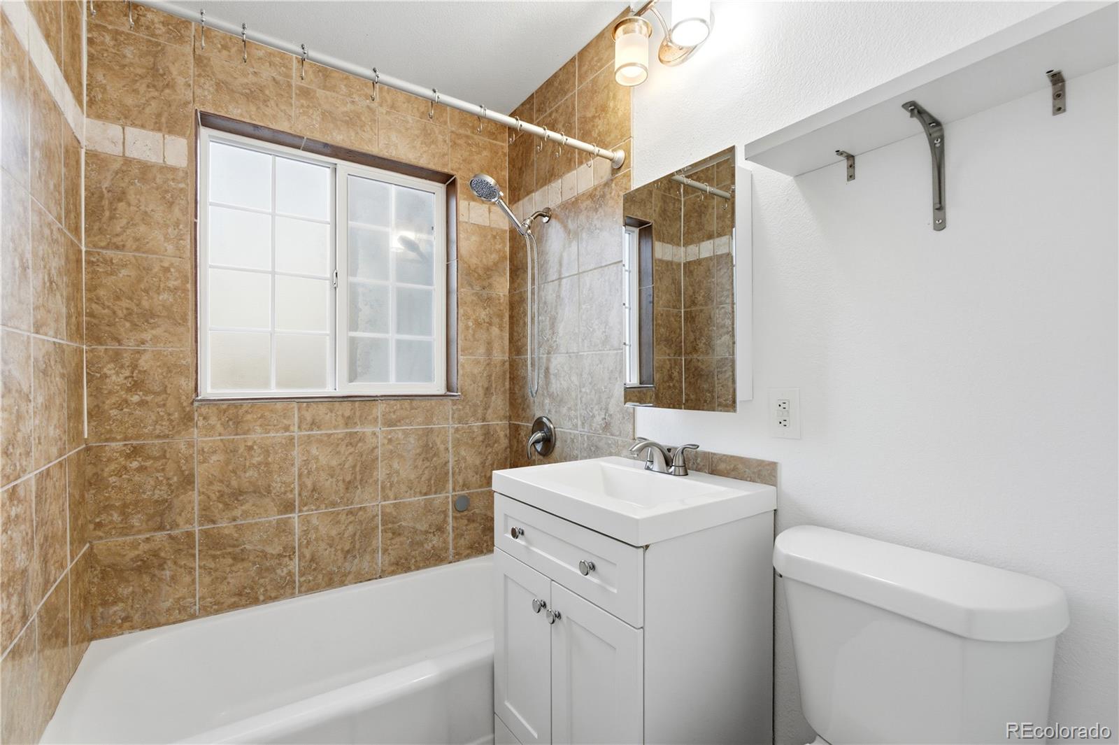 860 Lansing Street Aurora, CO 80010 - Photo 12 of 31 a bathroom with a sink a toilet and shower