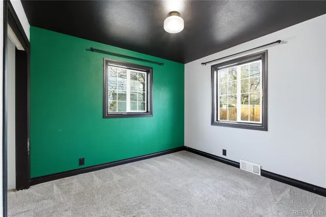 an empty room with a window and ceiling fan