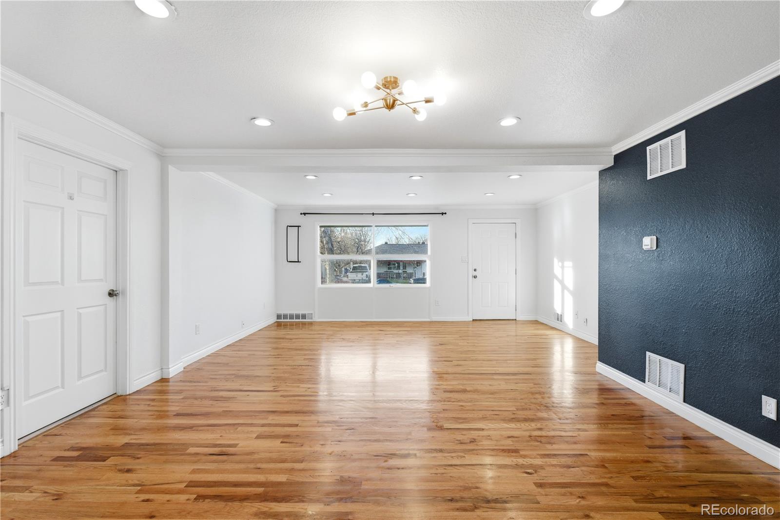 860 Lansing Street Aurora, CO 80010 - Photo 5 of 31 a view of an empty room with wooden floor and a window