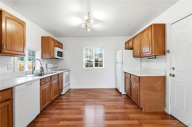 a kitchen with stainless steel appliances granite countertop wooden cabinets a sink a stove a window and island