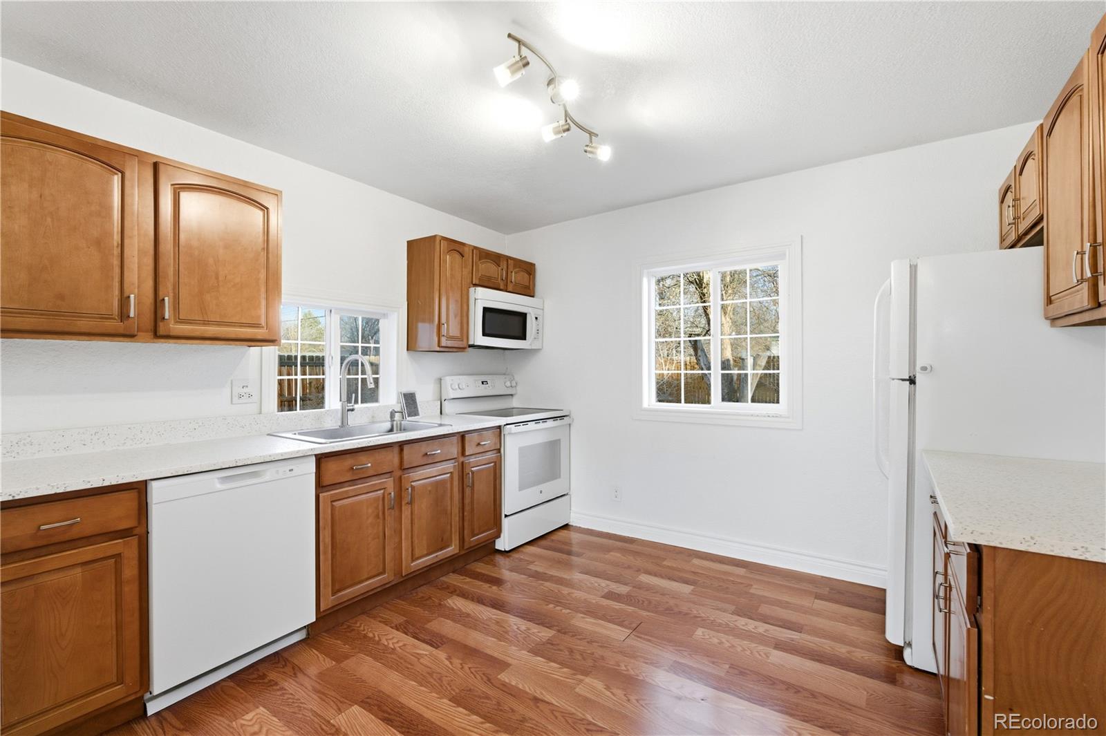 860 Lansing Street Aurora, CO 80010 - Photo 8 of 31 a kitchen with stainless steel appliances granite countertop a sink cabinets and wooden floor