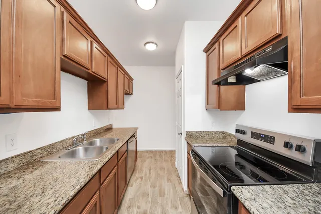 a kitchen with stainless steel appliances granite countertop a sink and stove