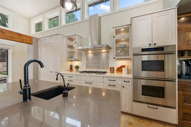 a kitchen with stainless steel appliances granite countertop a stove a sink and a refrigerator