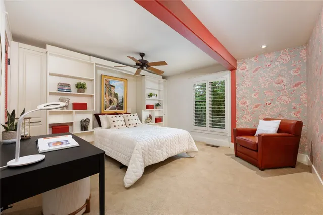 a bedroom with a bed a couch and a large window