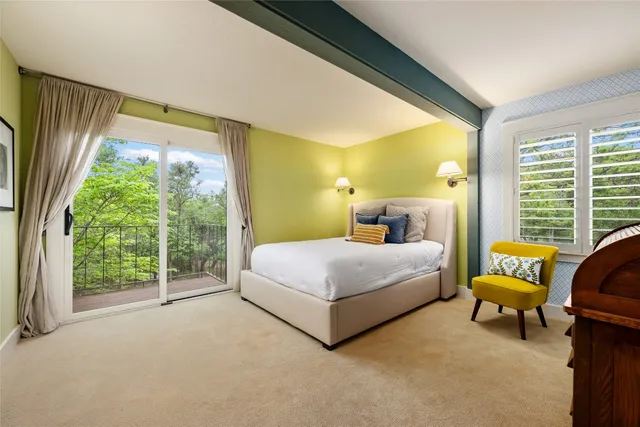 a bedroom with a bed chair and a large window