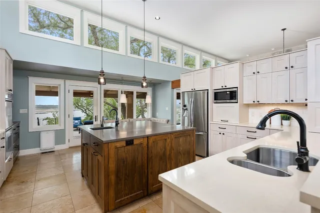 a kitchen with stainless steel appliances granite countertop a sink a stove and refrigerator