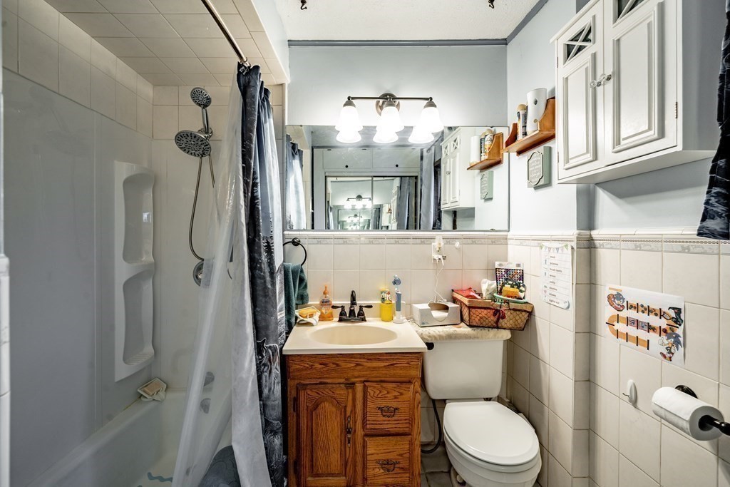 143 Gilbert Avenue Springfield, MA 01119 - Photo 23 of 37 a bathroom with a sink a toilet and shower curtain