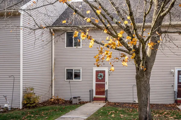 a view of a white house next to a yard