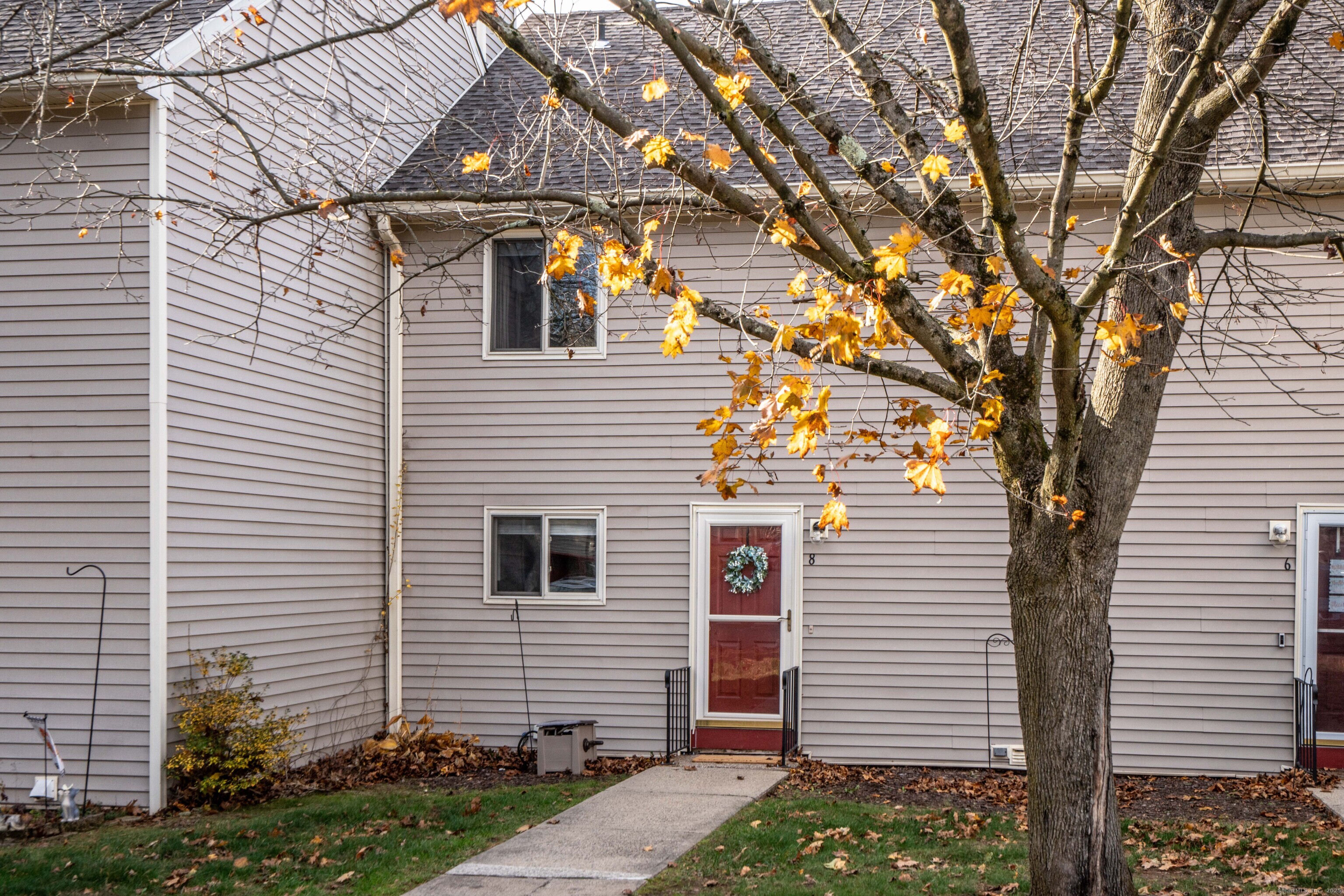 a view of a white house next to a yard
