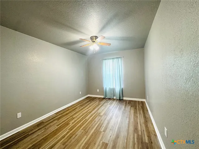 wooden floor in an empty room with a window
