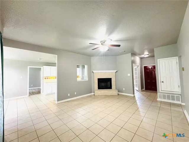 an empty room with fireplace and windows