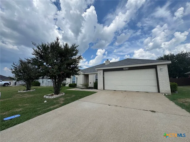 a view of a house with a yard and garage