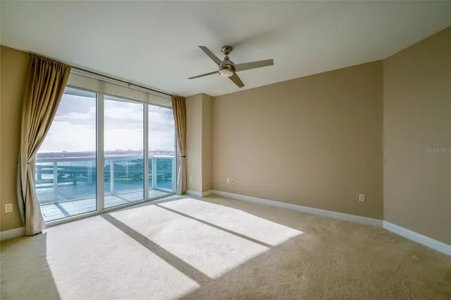 an empty room with window and a ceiling fan