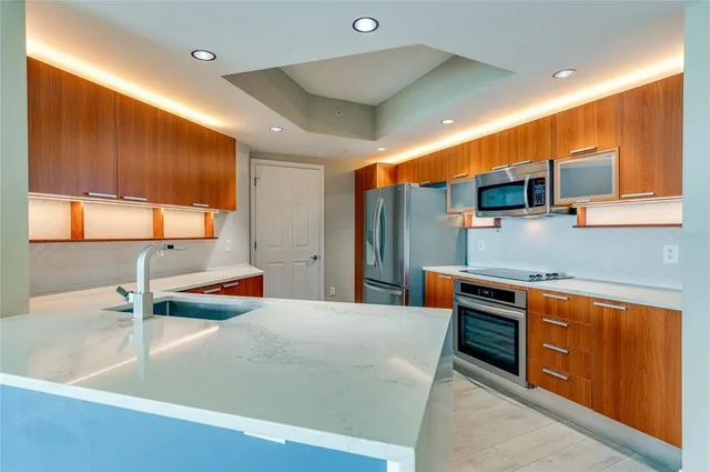a kitchen with stainless steel appliances a sink and a refrigerator
