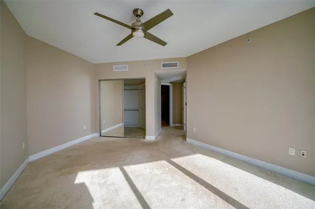a view of a big room with wooden floor and a ceiling fan